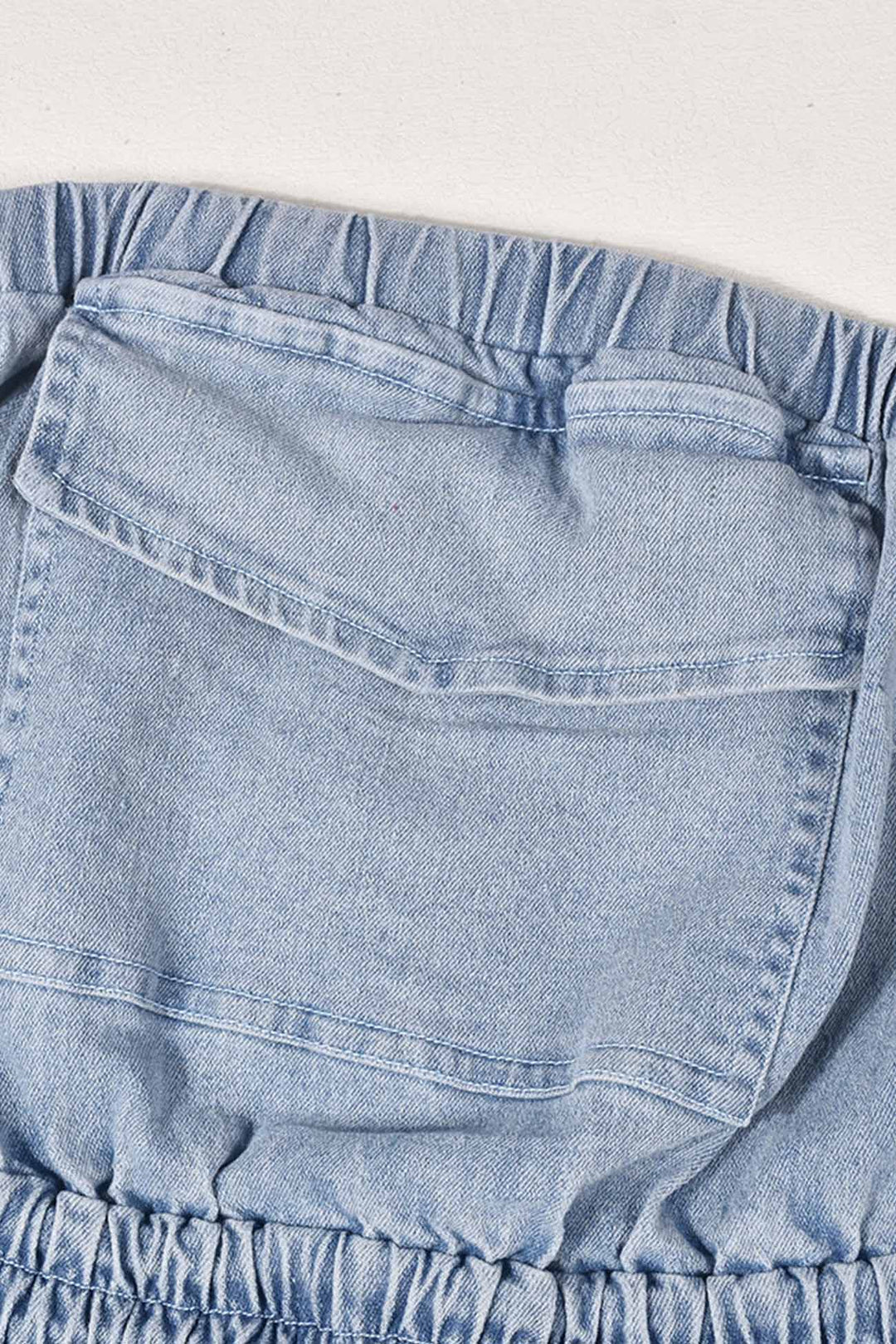 Tessa – Strapless Denim Jumpsuit met Grote Zak en Open Rug
