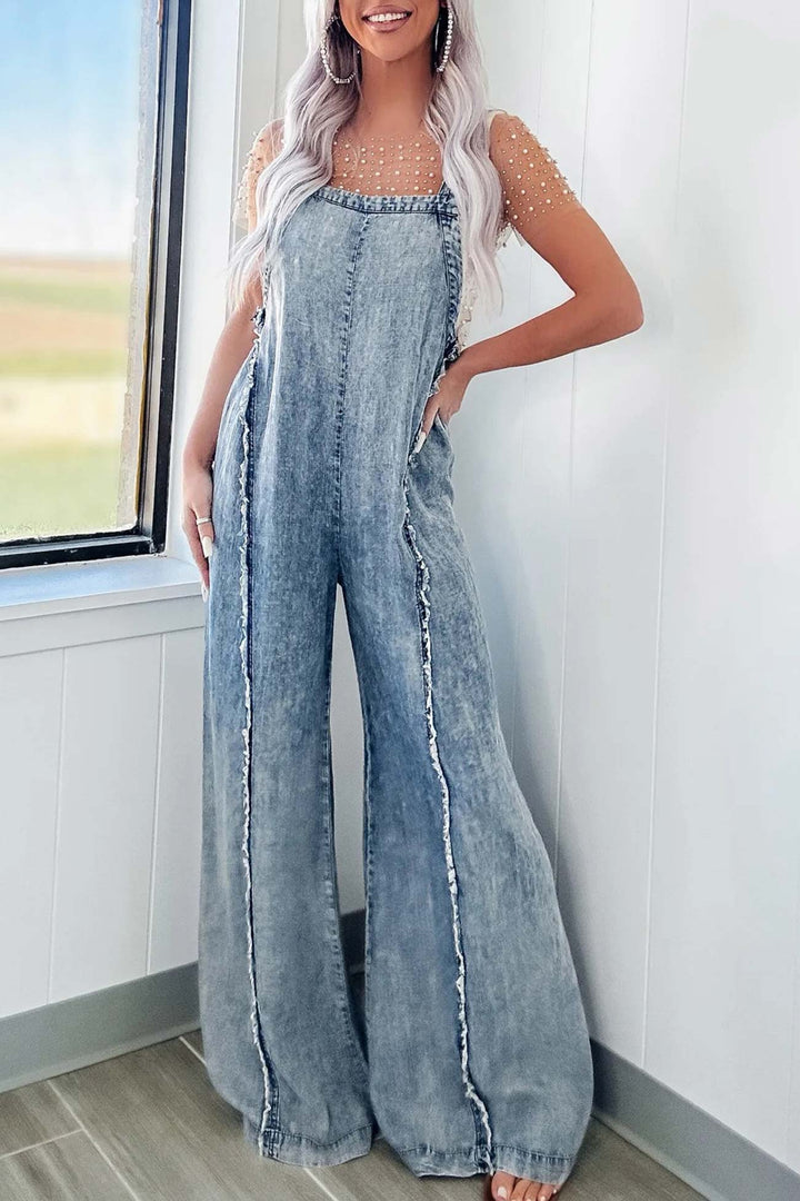 Nora – Washed Denim Jumpsuit met Ruwe Zoom en Wijde Pijpen